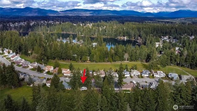 aerial view featuring a wooded view and a mountain view