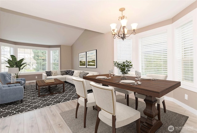 dining room featuring baseboards, lofted ceiling, light wood-type flooring, and a notable chandelier