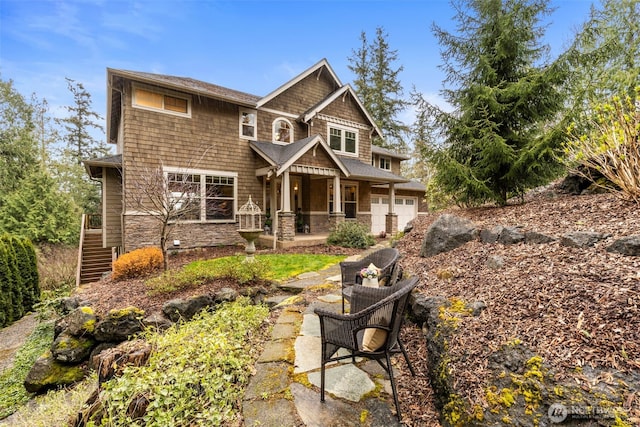 rear view of property with stone siding and a garage