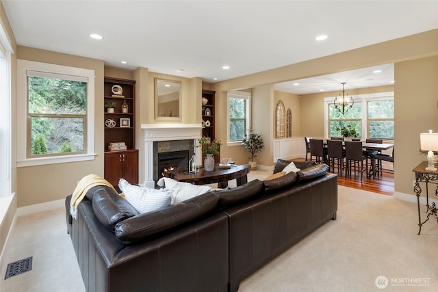 living room with an inviting chandelier, recessed lighting, a tile fireplace, and visible vents