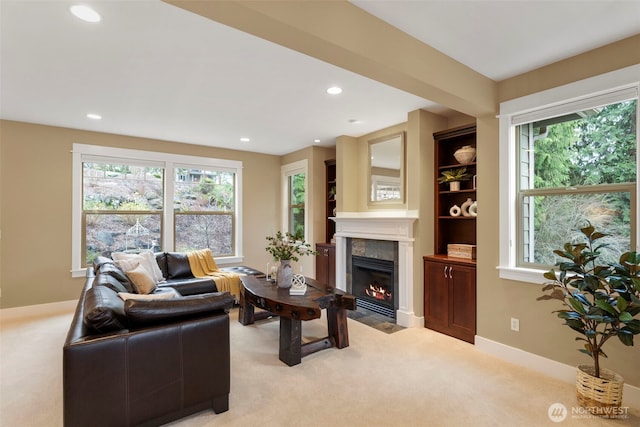 living area with a tile fireplace, light colored carpet, and recessed lighting
