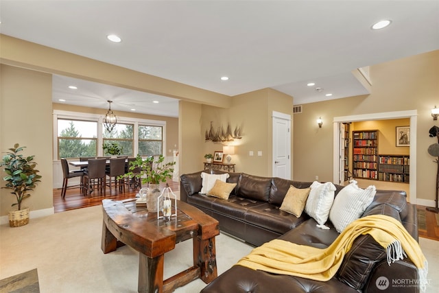 living area with visible vents, baseboards, a chandelier, and recessed lighting