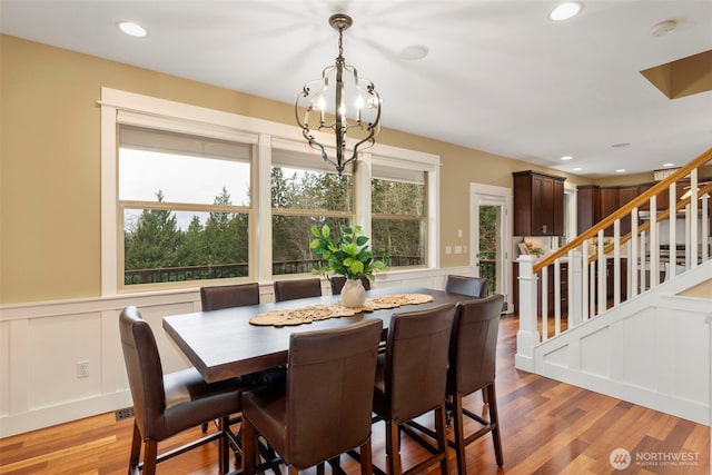 dining room featuring a wainscoted wall, stairs, wood finished floors, and recessed lighting