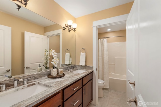 bathroom with double vanity, toilet, a sink, and tile patterned floors