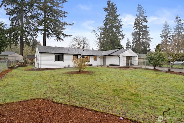 ranch-style home with a front yard and fence
