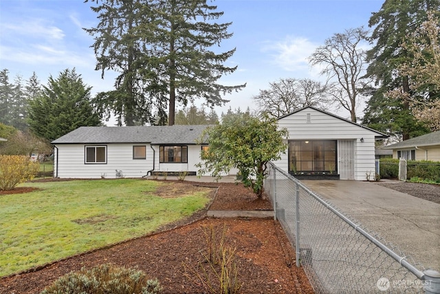 single story home with a front lawn, concrete driveway, and fence