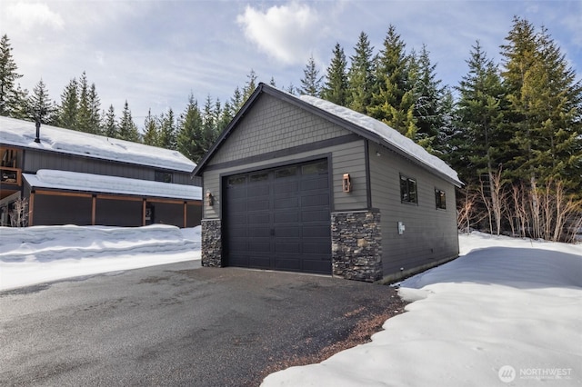 snow covered garage featuring a garage