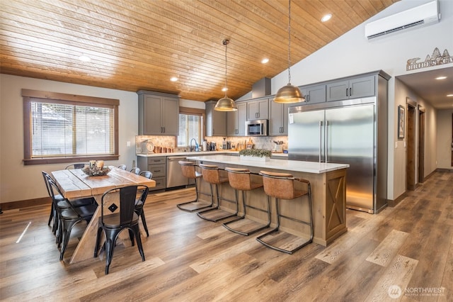 kitchen featuring an AC wall unit, light countertops, gray cabinets, wood ceiling, and stainless steel appliances
