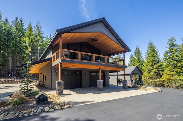 view of front facade featuring an attached garage, concrete driveway, and a balcony