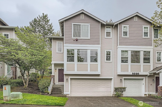 view of property with a garage and aphalt driveway