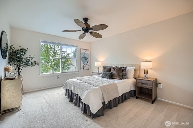 bedroom featuring light colored carpet, baseboards, and ceiling fan