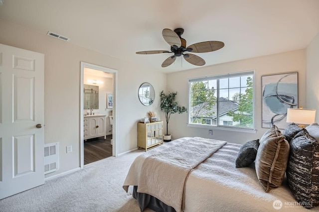 carpeted bedroom with visible vents, baseboards, ensuite bathroom, and ceiling fan