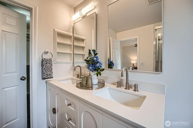 bathroom with a sink, double vanity, and visible vents