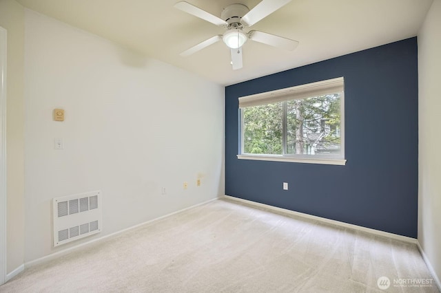 carpeted empty room with visible vents, a ceiling fan, and baseboards