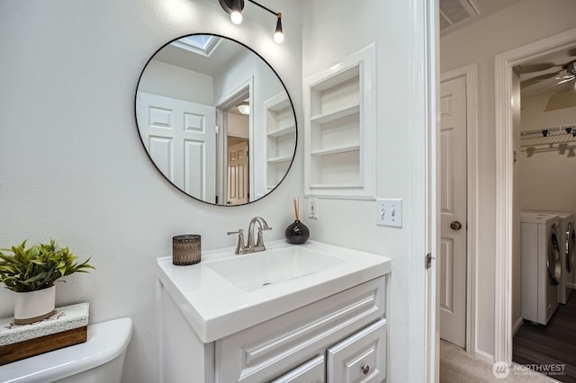 bathroom with toilet, visible vents, washing machine and dryer, and vanity