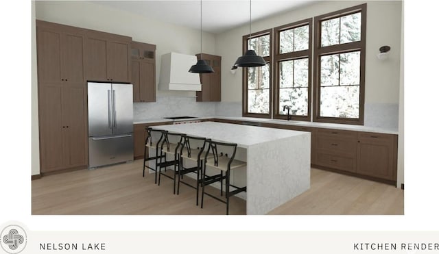 581 Wanawish Loop, Cle Elum, WA 98922 - kitchen featuring stainless steel refrigerator, premium range hood, black cooktop, tasteful backsplash, and a center island