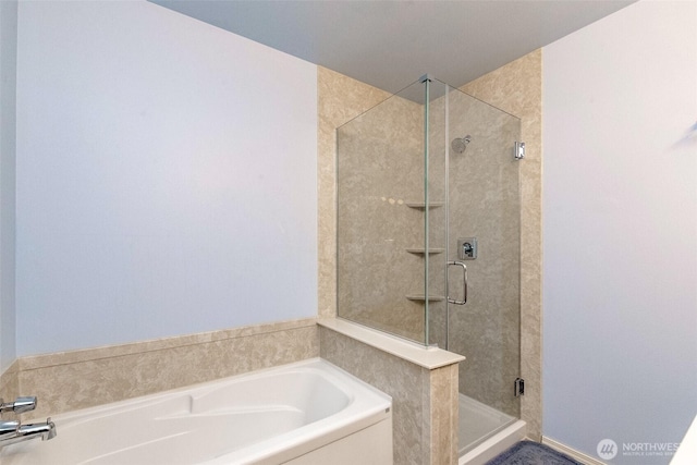 bathroom featuring a stall shower and a garden tub
