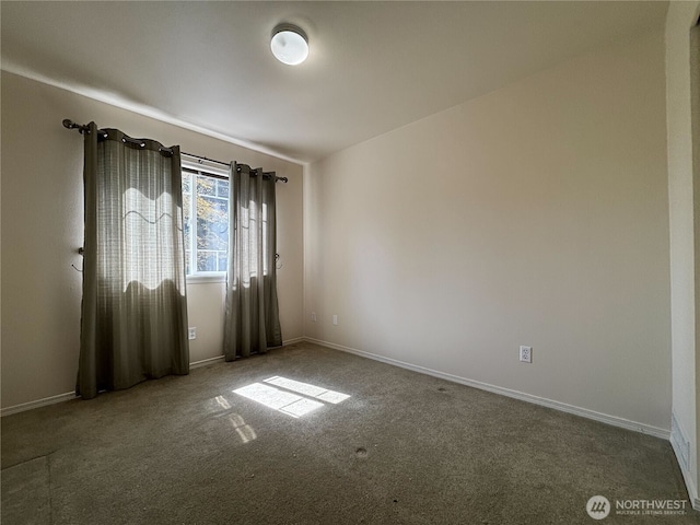 carpeted empty room featuring baseboards