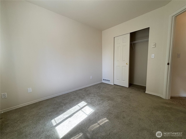 unfurnished bedroom featuring a closet, visible vents, baseboards, and carpet floors