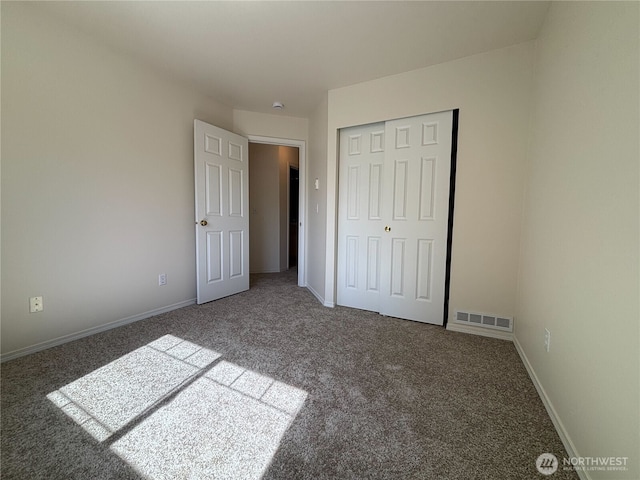 unfurnished bedroom featuring a closet, baseboards, carpet, and visible vents