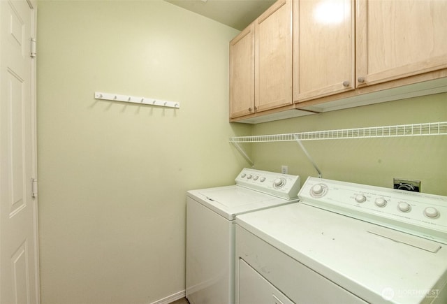 washroom with cabinet space, washer and clothes dryer, and baseboards