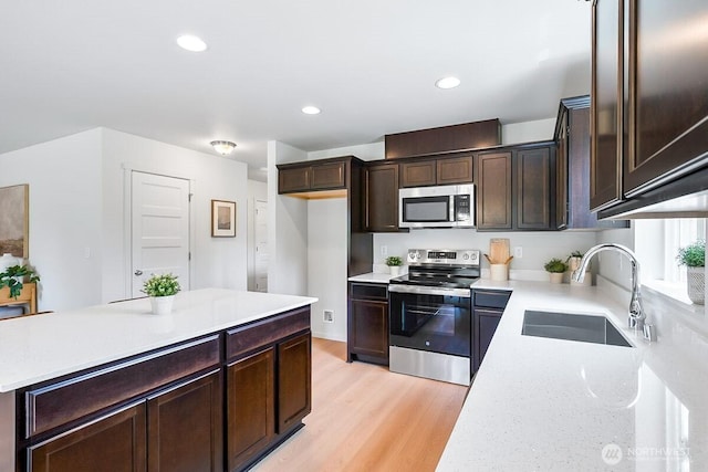 1512 Alder Ln, Gold Bar, WA 98251 - kitchen with stainless steel appliances, dark brown cabinetry, light wood-style floors, recessed lighting, and light stone countertops
