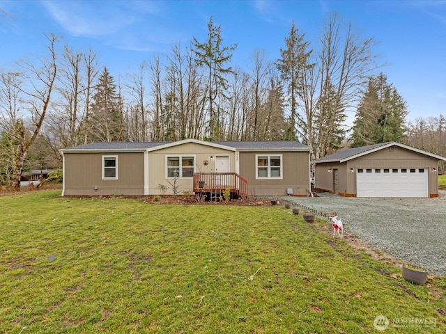 manufactured / mobile home featuring a front yard, a detached garage, and an outbuilding