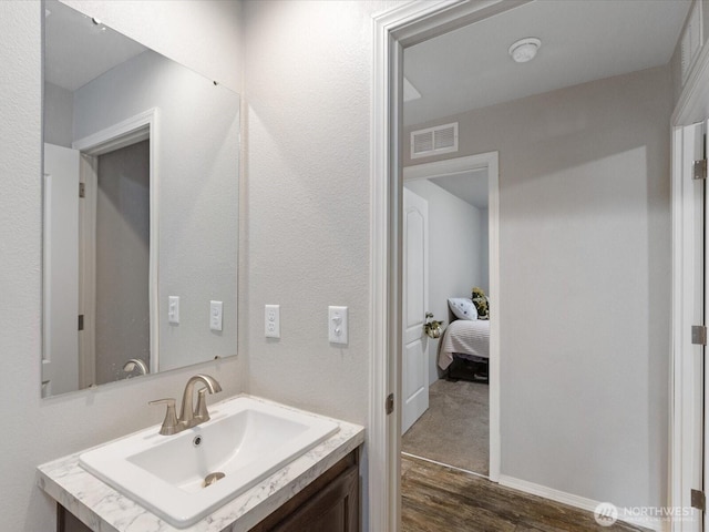 bathroom featuring wood finished floors, vanity, and visible vents