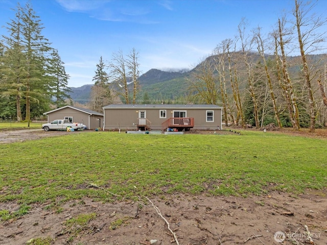 view of front of property featuring a deck with mountain view and a front yard