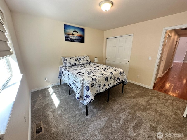 carpeted bedroom with baseboards, visible vents, and a closet