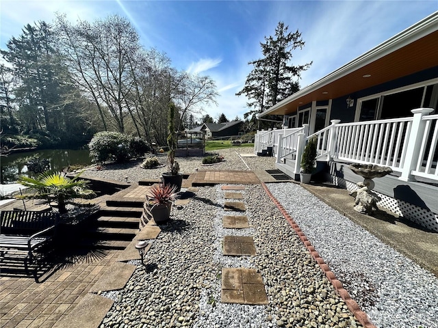 view of yard with a deck with water view
