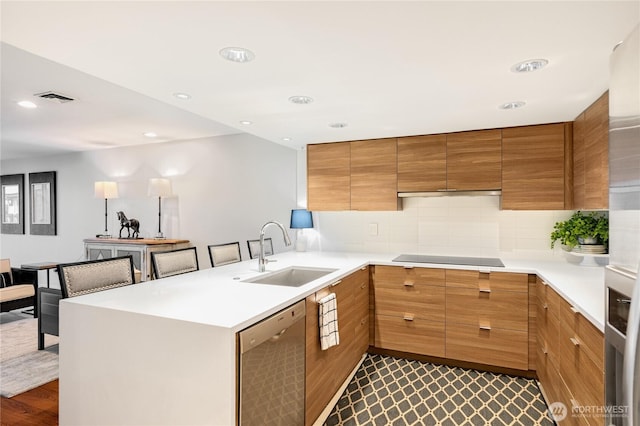 kitchen featuring visible vents, a sink, a peninsula, black electric cooktop, and dishwasher