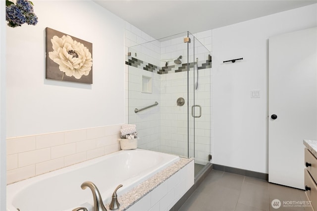 full bath featuring a shower stall, baseboards, a garden tub, tile patterned floors, and vanity