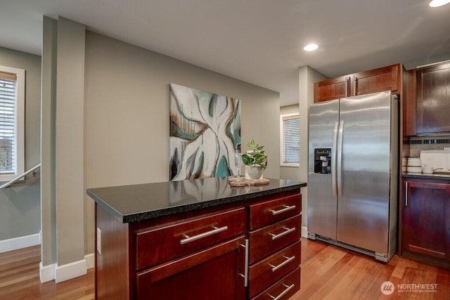 2120 W Ruffner St, Seattle, WA 98199 - kitchen with light wood-type flooring, dark countertops, dark brown cabinets, recessed lighting, and stainless steel fridge with ice dispenser