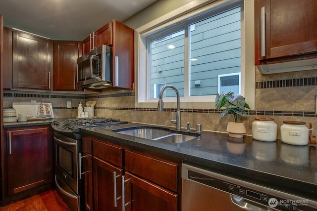 2120 W Ruffner St, Seattle, WA 98199 - kitchen with backsplash, dark countertops, stainless steel appliances, and a sink