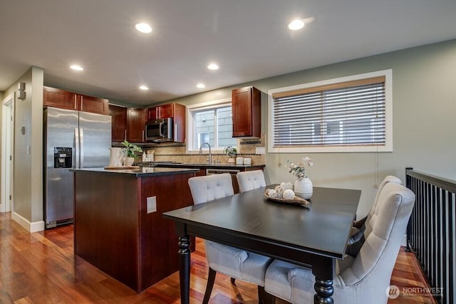 2120 W Ruffner St, Seattle, WA 98199 - kitchen featuring a center island, dark countertops, wood finished floors, radiator heating unit, and appliances with stainless steel finishes