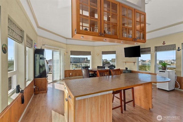 1412 Storm King Ave, Ocean Shores, WA 98569 - kitchen with ornamental molding, light wood-type flooring, glass insert cabinets, and brown cabinets