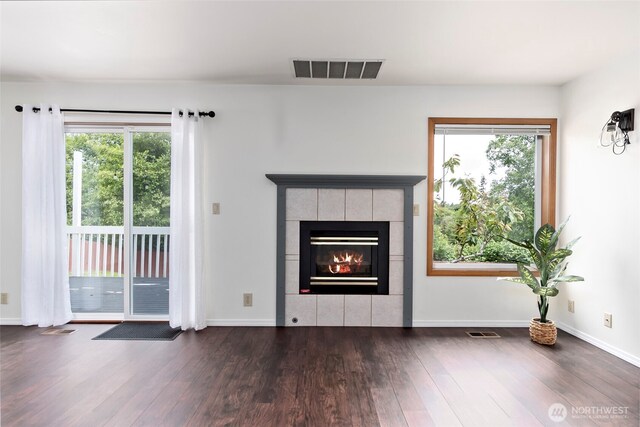 1442 SW Ponsteen Dr, Oak Harbor, WA 98277 - unfurnished living room featuring wood finished floors, a fireplace, plenty of natural light, and baseboards