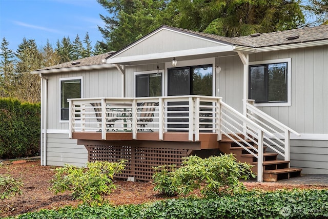 rear view of property featuring a wooden deck and a shingled roof