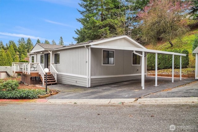manufactured / mobile home with aphalt driveway and an attached carport