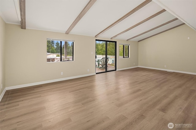 unfurnished room featuring lofted ceiling with beams, light wood-style flooring, plenty of natural light, and baseboards