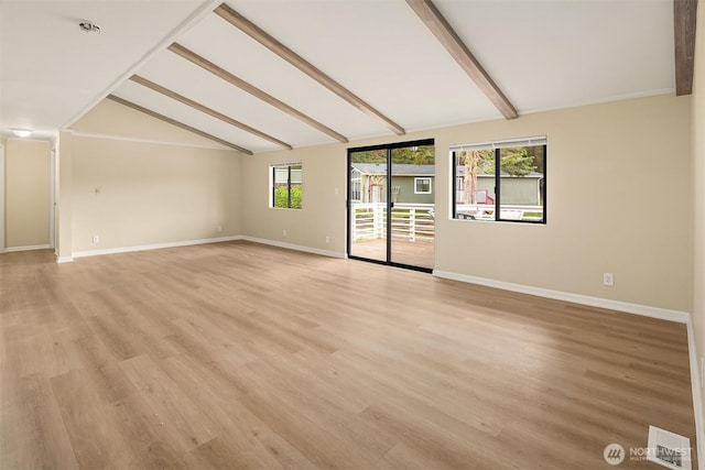 empty room with lofted ceiling with beams, visible vents, baseboards, and light wood-style floors