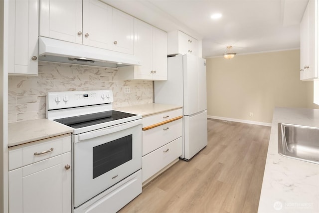 kitchen featuring under cabinet range hood, a sink, white cabinetry, white appliances, and decorative backsplash