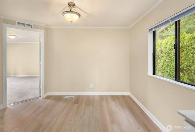 unfurnished room featuring visible vents, light wood-style flooring, crown molding, and baseboards