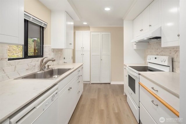 kitchen featuring under cabinet range hood, a sink, white appliances, light wood finished floors, and light countertops