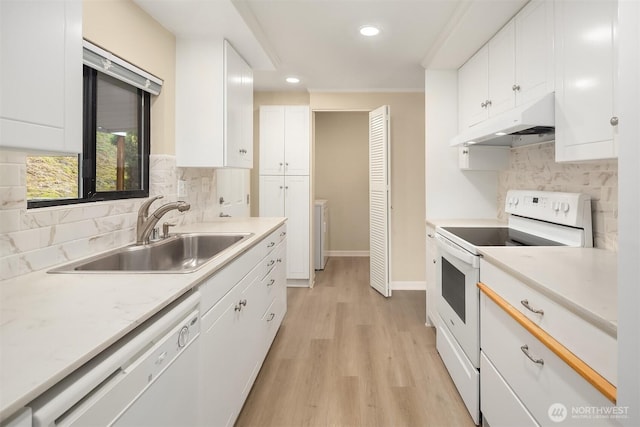 kitchen with white appliances, a sink, light countertops, under cabinet range hood, and white cabinetry