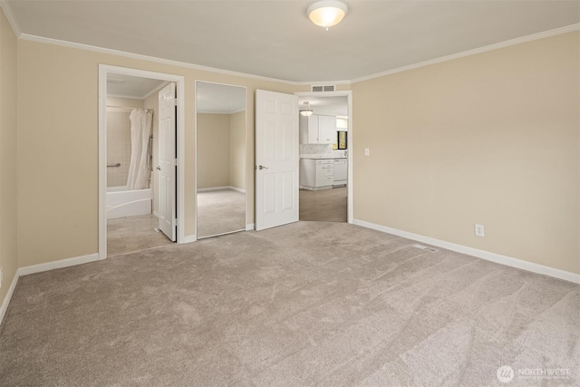 unfurnished bedroom with crown molding, carpet, visible vents, and baseboards