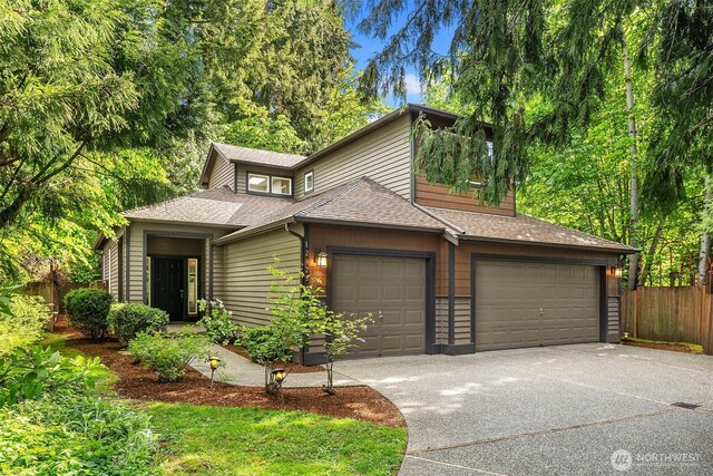 12423 NE 70th St, Kirkland, WA 98033 - view of front of house with fence, concrete driveway, a garage, and roof with shingles