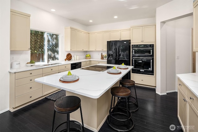 12423 NE 70th St, Kirkland, WA 98033 - kitchen with black appliances, a sink, dark wood-type flooring, a breakfast bar, and recessed lighting