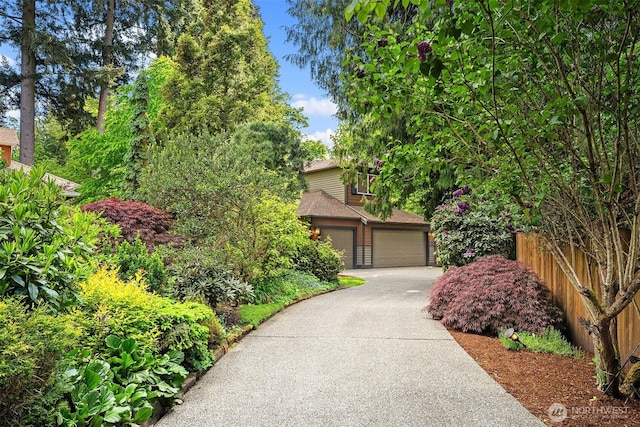 12423 NE 70th St, Kirkland, WA 98033 - obstructed view of property with fence, a garage, and a shingled roof